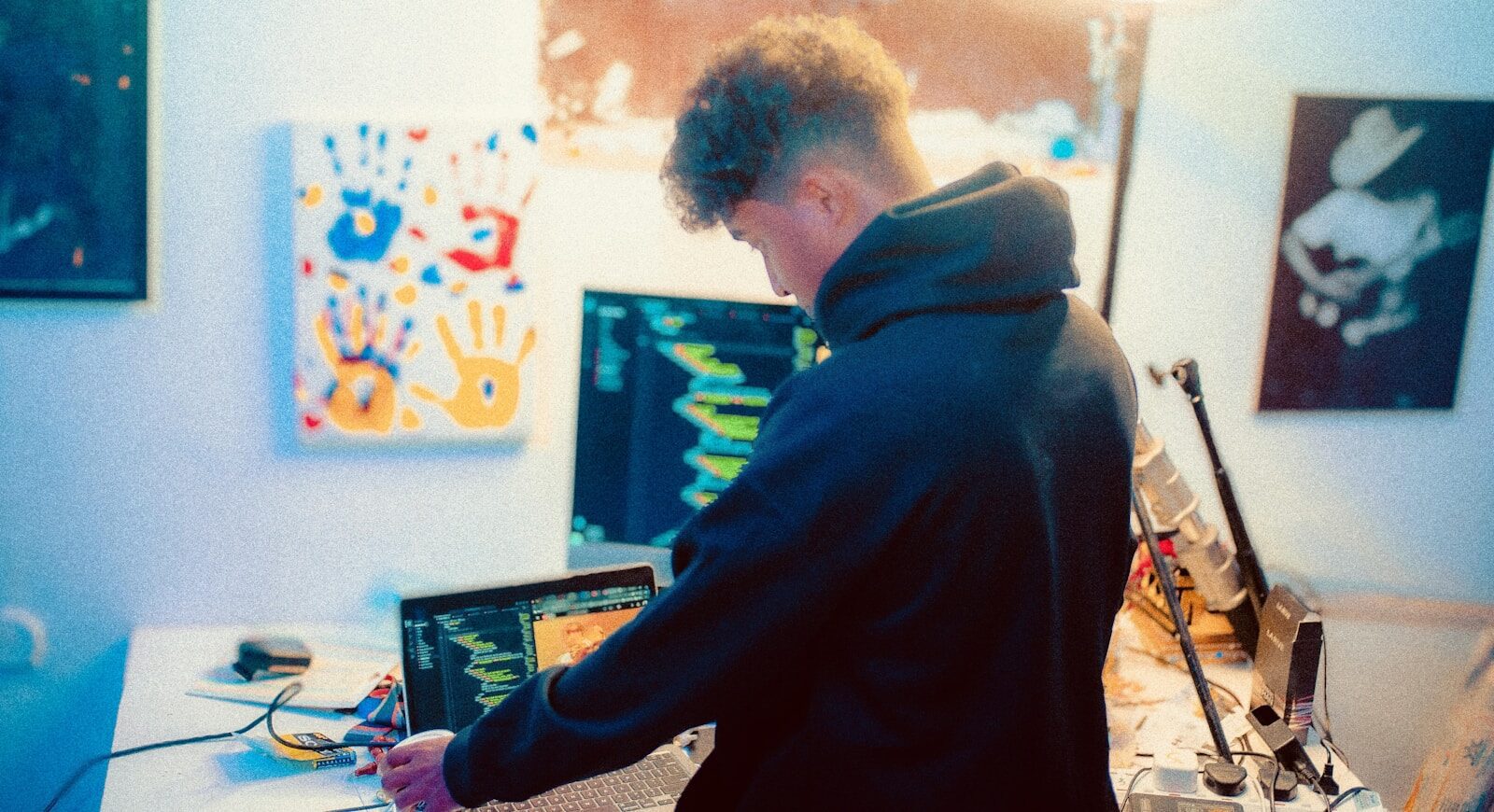 Artist curating printed artwork portfolio at studio table