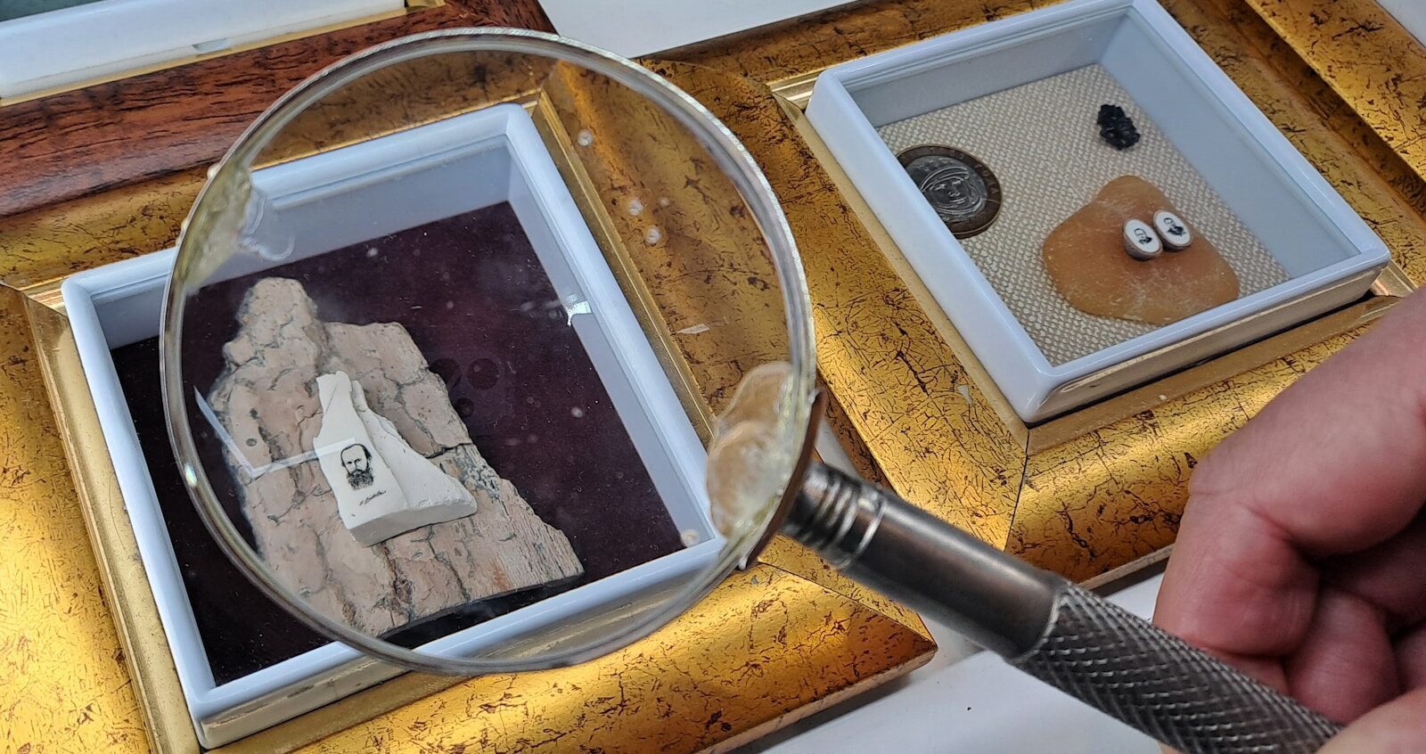 a hand holding a magnifying glass over a picture