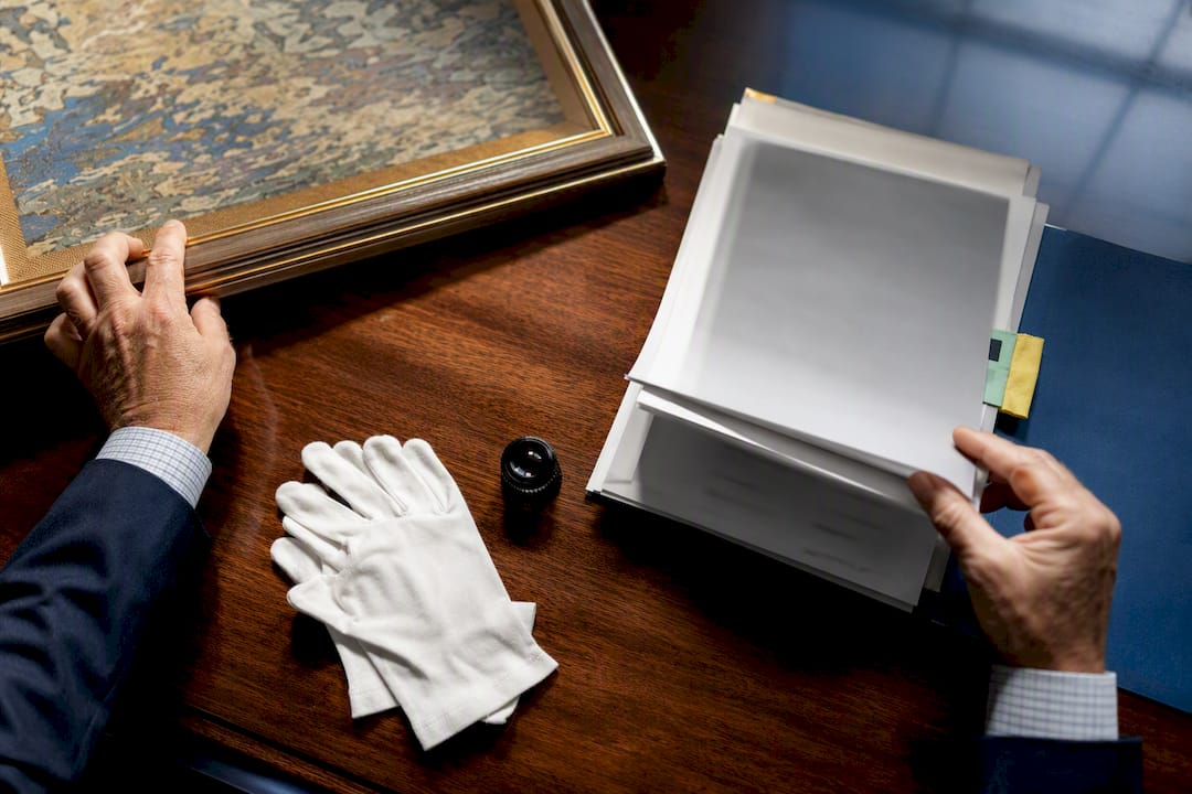 Underwriter reviewing art provenance records