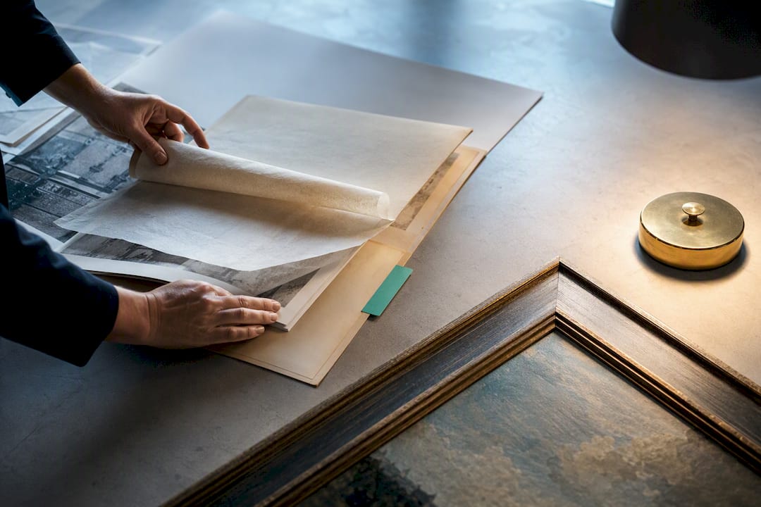 Hands verifying art provenance records