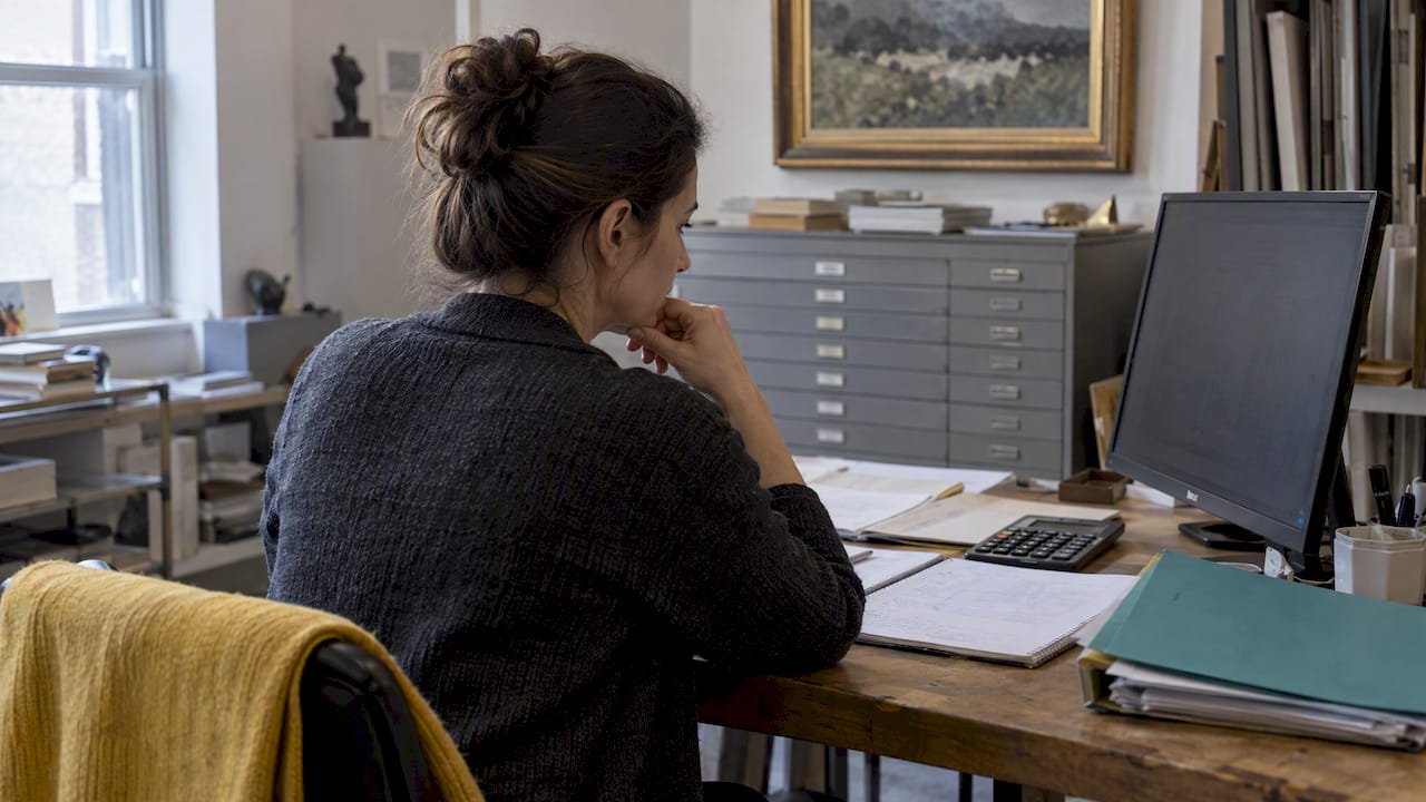 Gallery owner reviewing sales performance records